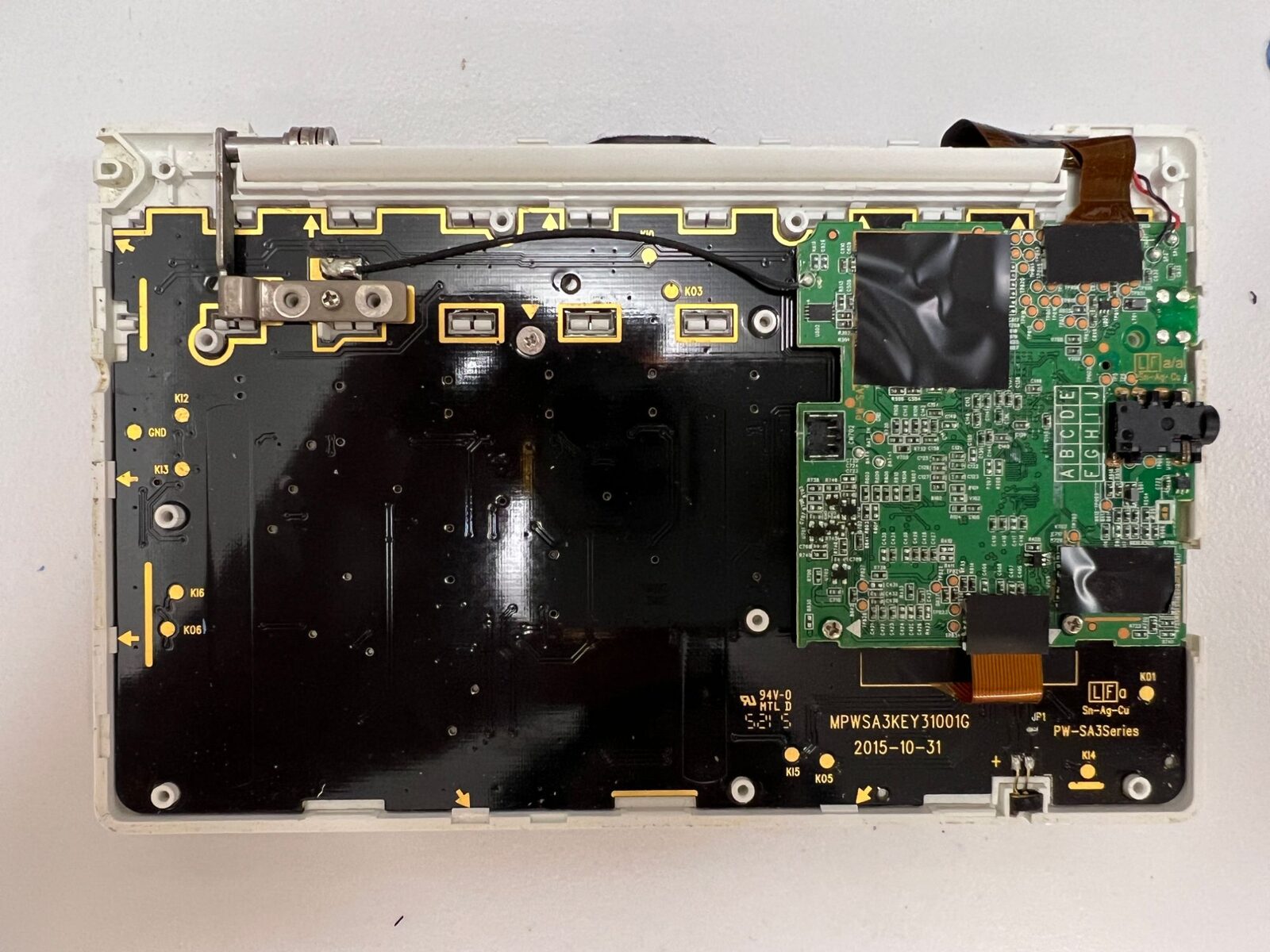 裏ぶたと内側のカバーを外したBrain PW-SH3。黒いキーボード基板の右上に、緑色のメイン基板が載っている。